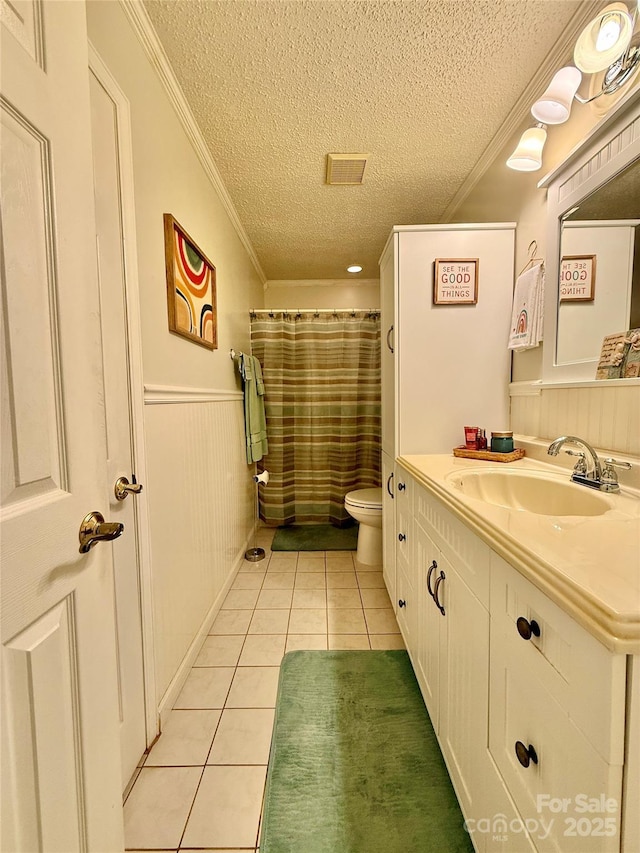 403 Kings Dr, Cherryville, NC 28021 - bathroom with a textured ceiling, tile patterned flooring, vanity, crown molding, and a wainscoted wall