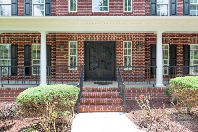 1009 Brookline Dr, Huntersville, NC 28078 - view of exterior entry featuring brick siding, french doors, and covered porch