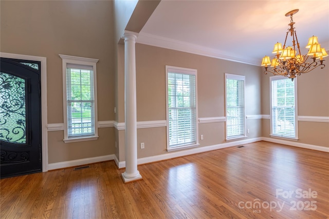 1009 Brookline Dr, Huntersville, NC 28078 - foyer with ornate columns, wood finished floors, a chandelier, and ornamental molding