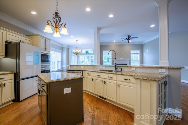 1009 Brookline Dr, Huntersville, NC 28078 - kitchen featuring freestanding refrigerator, a center island with sink, decorative columns, built in microwave, and a chandelier
