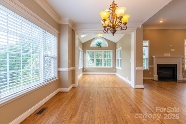 1009 Brookline Dr, Huntersville, NC 28078 - unfurnished dining area with a chandelier, wood finished floors, a fireplace, ornamental molding, and lofted ceiling