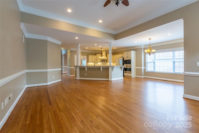 1009 Brookline Dr, Huntersville, NC 28078 - unfurnished living room featuring a ceiling fan, a chandelier, light wood-style floors, recessed lighting, and ornamental molding