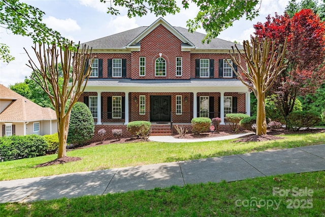 1009 Brookline Dr, Huntersville, NC 28078 - georgian-style home with brick siding, covered porch, a front yard, and roof with shingles