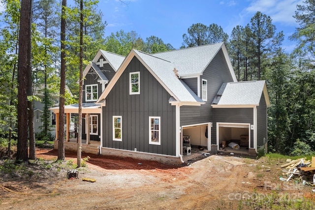6782 Kingfisher Ct, Denver, NC 28037 - view of front of property featuring board and batten siding, an attached garage, dirt driveway, and roof with shingles