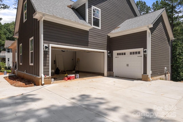 6782 Kingfisher Ct, Denver, NC 28037 - view of side of property with a shingled roof, concrete driveway, and board and batten siding