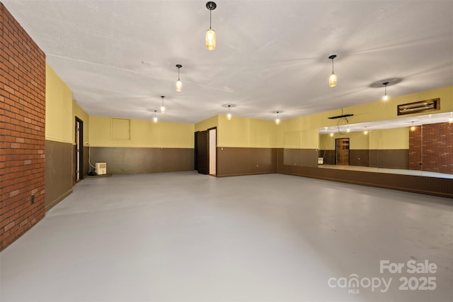 2 Candlestick Dr, Zirconia, NC 28790 - interior space featuring brick wall, wainscoting, and finished concrete floors