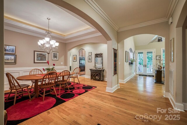 9002 Fair Oak Dr, Sherrills Ford, NC 28673 - dining area featuring arched walkways, light wood-style flooring, a chandelier, ornamental molding, and french doors