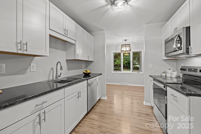 13446 Idlefield Ln, Matthews, NC 28105 - kitchen with stainless steel appliances, a sink, white cabinetry, and baseboards