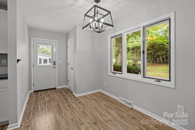 13446 Idlefield Ln, Matthews, NC 28105 - unfurnished dining area featuring baseboards, a chandelier, and light wood-style flooring