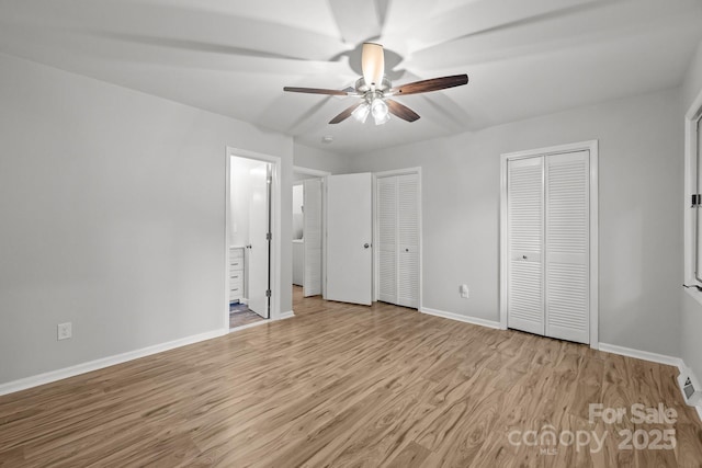13446 Idlefield Ln, Matthews, NC 28105 - unfurnished bedroom with multiple closets, baseboards, wood finished floors, ensuite bathroom, and ceiling fan