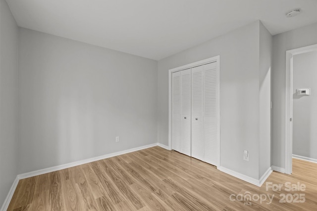 13446 Idlefield Ln, Matthews, NC 28105 - unfurnished bedroom featuring light wood-style floors, baseboards, and a closet