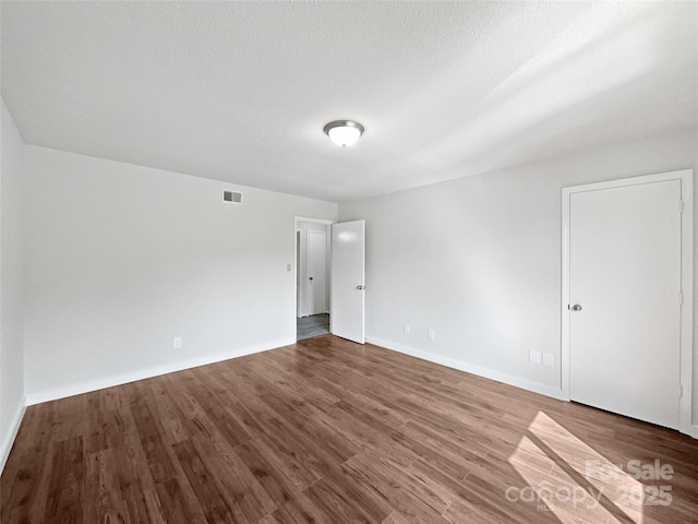 1908 Harvest Ln Unit 5, Charlotte, NC 28210 - empty room featuring wood finished floors, baseboards, and a textured ceiling