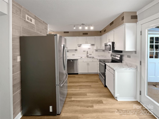 1908 Harvest Ln Unit 5, Charlotte, NC 28210 - kitchen with appliances with stainless steel finishes, light wood-style floors, a sink, white cabinets, and light stone countertops