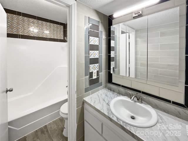 1908 Harvest Ln Unit 5, Charlotte, NC 28210 - full bath with toilet, wood finished floors, a textured ceiling, tile walls, and vanity