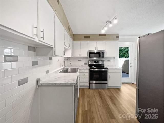 1908 Harvest Ln Unit 5, Charlotte, NC 28210 - kitchen featuring appliances with stainless steel finishes, a sink, white cabinetry, and light wood-style floors