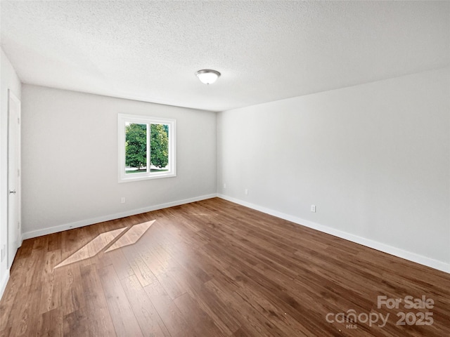 1908 Harvest Ln Unit 5, Charlotte, NC 28210 - unfurnished room with wood finished floors, baseboards, and a textured ceiling