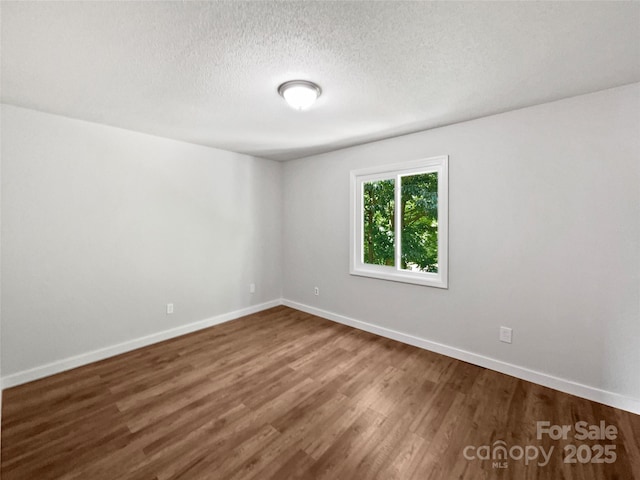 1908 Harvest Ln Unit 5, Charlotte, NC 28210 - unfurnished room with dark wood finished floors, baseboards, and a textured ceiling