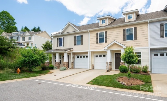 207 Stoney Point Way, Candler, NC 28715 - view of front of home featuring driveway, stone siding, an attached garage, and roof with shingles