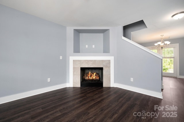 207 Stoney Point Way, Candler, NC 28715 - unfurnished living room featuring wood finished floors, a chandelier, a fireplace, and baseboards