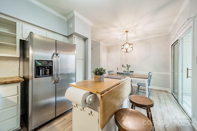 5927 Quail Hollow Rd Unit H, Charlotte, NC 28210 - kitchen featuring stainless steel refrigerator with ice dispenser, butcher block countertops, light wood-type flooring, decorative backsplash, and a chandelier