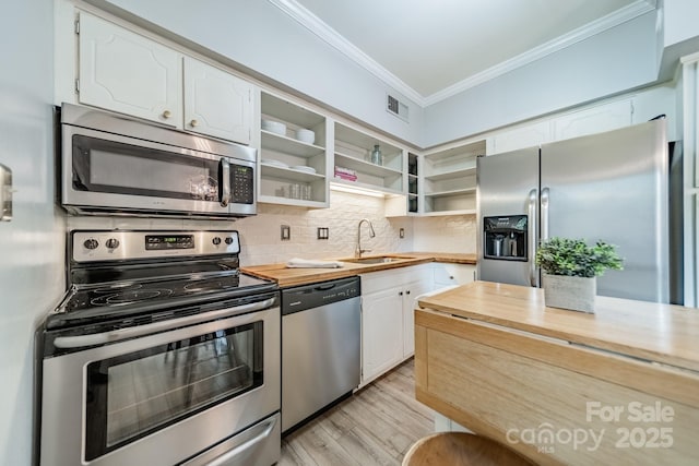 5927 Quail Hollow Rd Unit H, Charlotte, NC 28210 - kitchen with stainless steel appliances, butcher block countertops, a sink, crown molding, and open shelves