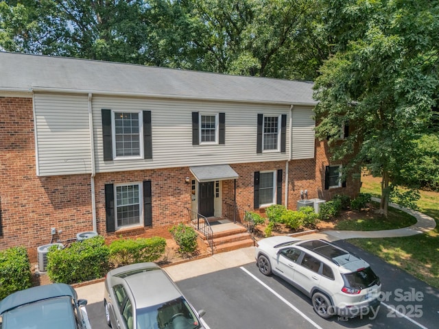 5927 Quail Hollow Rd Unit H, Charlotte, NC 28210 - view of property with uncovered parking, brick siding, and cooling unit