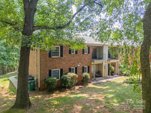 5927 Quail Hollow Rd Unit H, Charlotte, NC 28210 - rear view of house with a balcony, brick siding, a lawn, and a patio