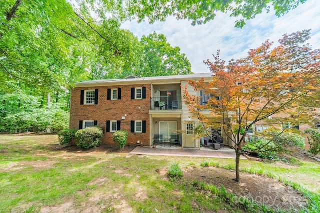 5927 Quail Hollow Rd Unit H, Charlotte, NC 28210 - back of property featuring a balcony, brick siding, a patio, and a lawn