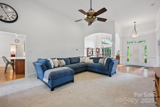 12900 Westmoreland Rd, Huntersville, NC 28078 - living area with ornamental molding, arched walkways, light wood-type flooring, a chandelier, and ceiling fan