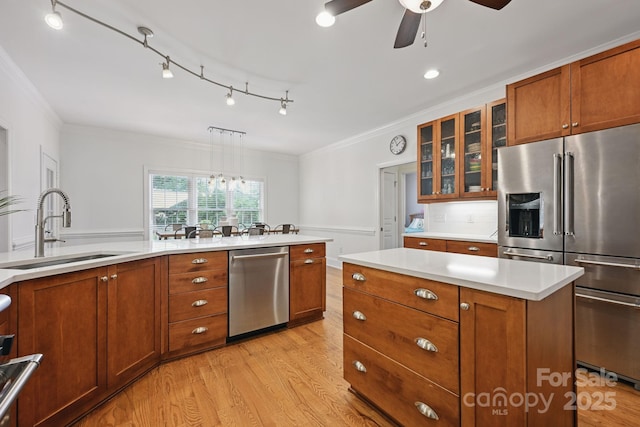 12900 Westmoreland Rd, Huntersville, NC 28078 - kitchen with appliances with stainless steel finishes, a sink, crown molding, brown cabinetry, and wainscoting