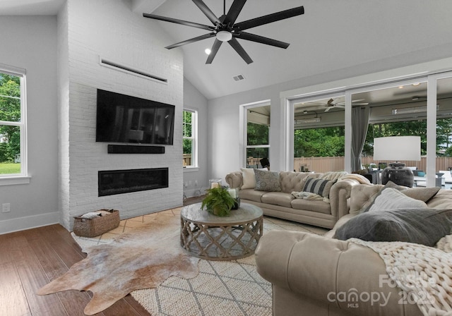 4021 Redwood Ave, Charlotte, NC 28205 - living area featuring ceiling fan, wood finished floors, baseboards, a fireplace, and high vaulted ceiling