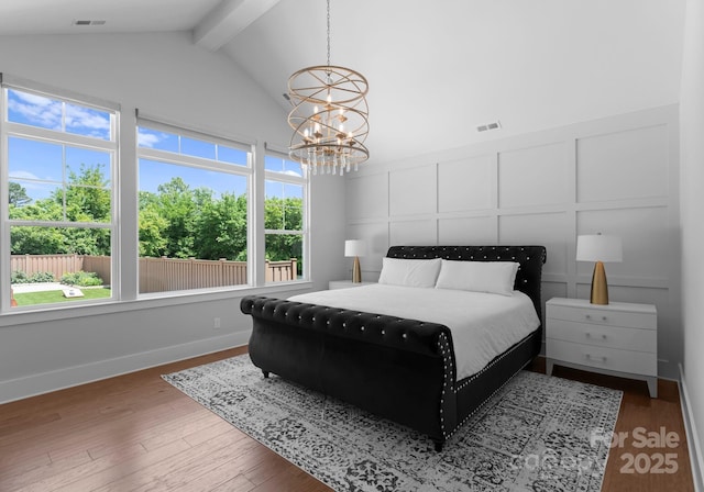 4021 Redwood Ave, Charlotte, NC 28205 - bedroom with beam ceiling, a chandelier, multiple windows, wood finished floors, and baseboards