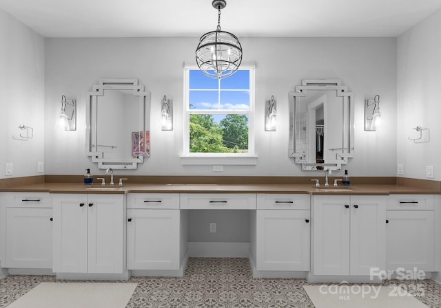 4021 Redwood Ave, Charlotte, NC 28205 - bathroom featuring double vanity, a chandelier, tile patterned floors, and baseboards