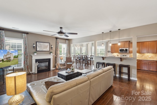 4430 Bravery Pl SW, Concord, NC 28027 - living area featuring dark wood finished floors, ceiling fan, and a fireplace with flush hearth