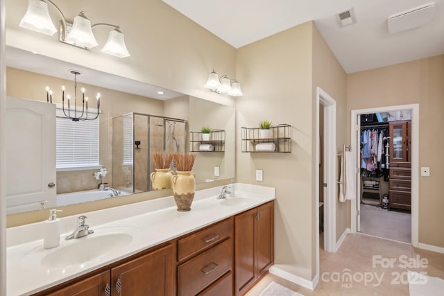 4430 Bravery Pl SW, Concord, NC 28027 - full bathroom with a shower stall, a chandelier, a walk in closet, double vanity, and tile patterned flooring