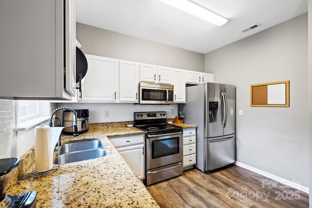 20 Daphne Dr, Arden, NC 28704 - kitchen with appliances with stainless steel finishes, a sink, dark wood-type flooring, white cabinetry, and tasteful backsplash