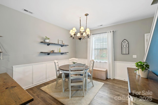 20 Daphne Dr, Arden, NC 28704 - dining area featuring a chandelier, a wainscoted wall, wood finished floors, and a decorative wall