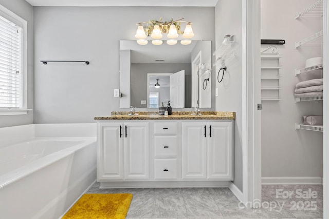 20 Daphne Dr, Arden, NC 28704 - full bath with double vanity, a garden tub, a walk in closet, a chandelier, and baseboards