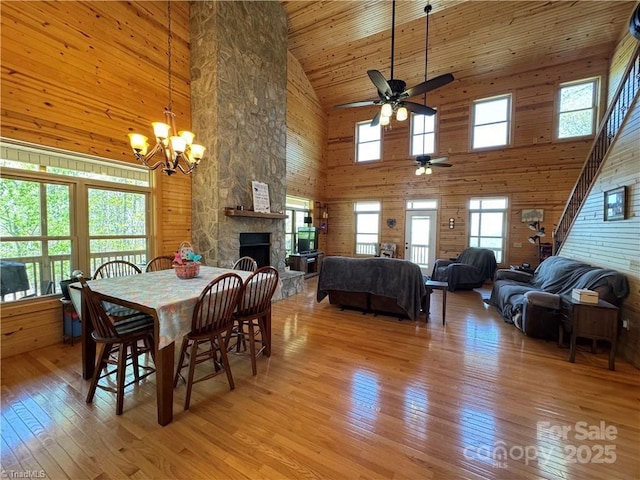 658 Green Point Ln, Boomer, NC 28606 - dining room featuring high vaulted ceiling, ceiling fan, light wood-type flooring, a chandelier, and a stone fireplace
