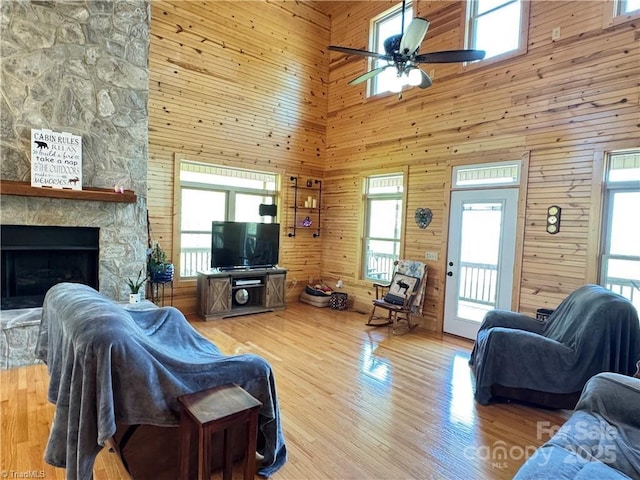 658 Green Point Ln, Boomer, NC 28606 - living area featuring a towering ceiling, wood walls, a ceiling fan, healthy amount of natural light, and a fireplace