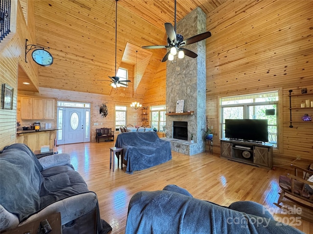 658 Green Point Ln, Boomer, NC 28606 - living area featuring high vaulted ceiling, ceiling fan, wooden walls, light wood-style floors, and a stone fireplace