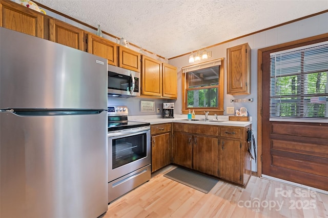 37 Sassafras Ln, Maggie Valley, NC 28751 - kitchen featuring appliances with stainless steel finishes, ornamental molding, light countertops, a textured ceiling, and light wood finished floors