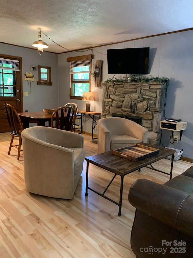37 Sassafras Ln, Maggie Valley, NC 28751 - living area with a textured ceiling, light wood-type flooring, ornamental molding, and a stone fireplace