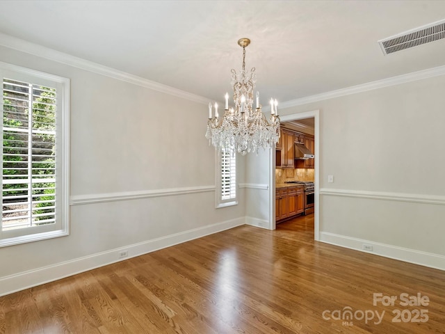 1522 High St, Charlotte, NC 28211 - unfurnished dining area featuring a chandelier, healthy amount of natural light, wood finished floors, and ornamental molding