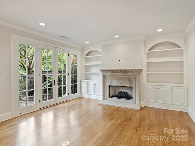 1522 High St, Charlotte, NC 28211 - unfurnished living room with crown molding, built in features, a fireplace with raised hearth, wood finished floors, and baseboards