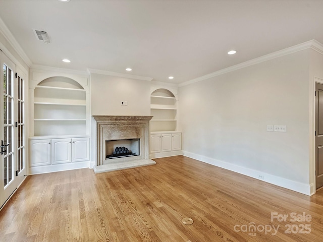 1522 High St, Charlotte, NC 28211 - unfurnished living room with ornamental molding, baseboards, built in shelves, a fireplace with raised hearth, and light wood-style flooring