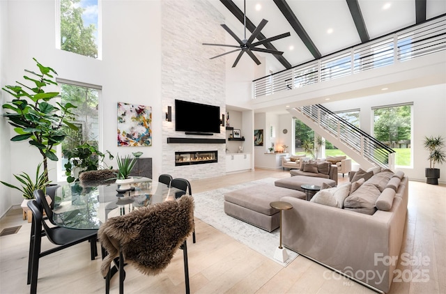 5925 Creola Rd, Charlotte, NC 28270 - living room with a high ceiling, a fireplace, beamed ceiling, a ceiling fan, and plenty of natural light