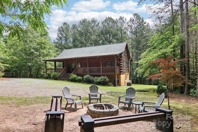 145 Jobes Trl, Mill Spring, NC 28756 - back of property with an outdoor fire pit, log exterior, a lawn, and a forest view