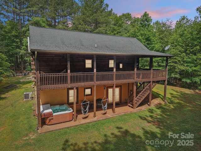 145 Jobes Trl, Mill Spring, NC 28756 - back of house at dusk featuring a hot tub, a wooden deck, french doors, a yard, and a patio