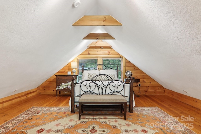 145 Jobes Trl, Mill Spring, NC 28756 - bedroom with wood finished floors, wood walls, vaulted ceiling, and a textured ceiling